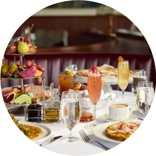 A table with an array of drinks and food displayed on a tiered stand, and plates.